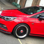 Red and black car with black rims